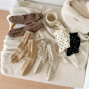 Cozy group of wool polka dot socks in various colors on a soft white fleece background