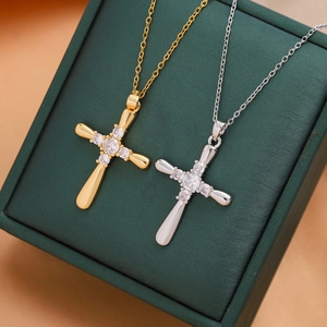 Chic gold and silver cross necklaces with micro-pave zircons on a leather jewelry box