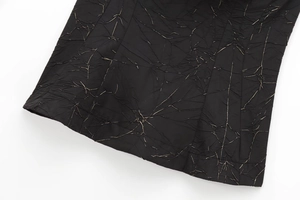 Macro shot of black pleated fabric texture with metallic thread detail on sexy crop top
