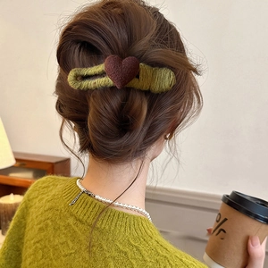 Olive green knitted heart hair clip for women styled in a hair tie for a cozy autumn look
