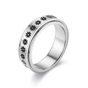 Close-up of rotatable stainless steel ring with black daisy floral pattern on silver finish