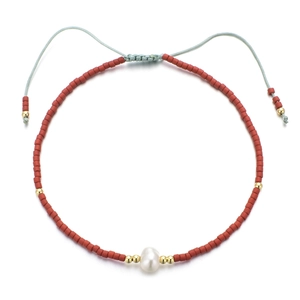 Détail du bracelet en perles Miyuki rouges avec pendentif perle et cordon bleu