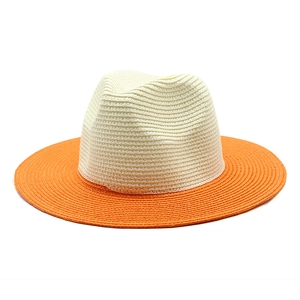 Close-up of dual-tone straw panama hat with beige crown and bright orange brim weave