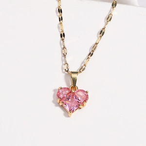 Close-up of pink heart-shaped crystal pendant on a flat gold titanium steel chain
