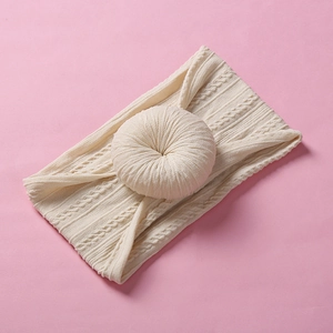 Makroaufnahme von cremefarbenem Jacquard-Babystirnband mit weichem Donut-Knoten-Detail