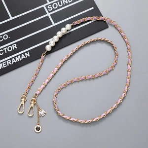 Detail of woven purple leather gold chain with pearls, camellia and jacket charms