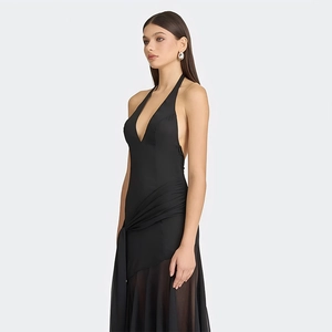 Detail of sheer asymmetrical skirt with tie-waist and ruffles on black halter dress
