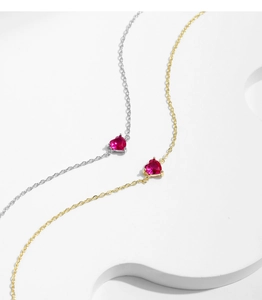 Detailed view of silver and gold heart bracelets with red heart-shaped zircon stones