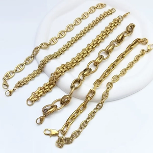 Detail of five gold stainless steel bracelet styles including pig nose and link chains