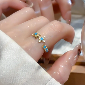 Macro detail of 18k gold plated star ring with turquoise blue stone and cubic zirconia