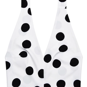 Detailed view of white dress with black polka dots featuring halter neck design tie