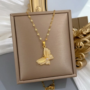 Golden butterfly necklace with cat eye stone and cubic zirconia on a brown gift box