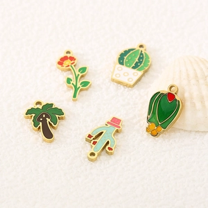 Detailed close-up of colorful enamel plant charms including cactus and palm tree designs