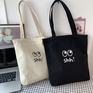 Detalle de bolsos tote de lona en blanco y negro con estampado de dibujos 'OO shh!'
