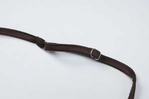 Détail des bretelles réglables avec boucle en métal argenté sur le haut marron foncé