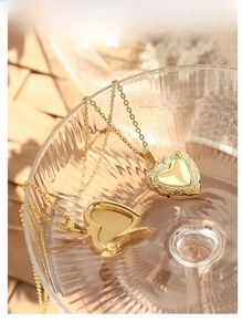 Detail of vintage 18K gold heart locket necklace with fine floral carvings inside a glass