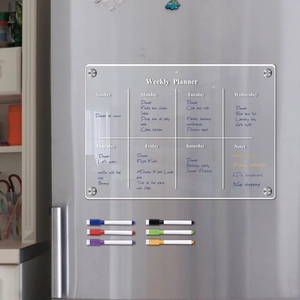Macro shot of magnetic acrylic weekly planner on fridge with six colorful dry-erase markers
