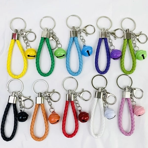 Flat lay of colorful braided leather keychain straps with bells in ten vibrant colors