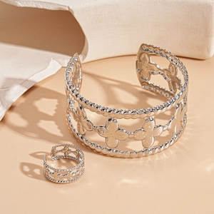 Close-up of silver hollow floral clover bracelet and matching ring set with beaded edges