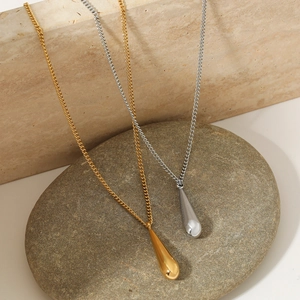 Minimalist gold and silver teardrop pendant necklaces on natural stone surface