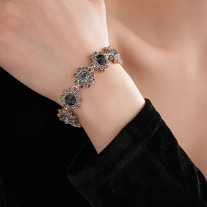 Detail of vintage flower bracelet with dark grey crystals on model's wrist