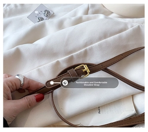 Detailed close-up of the adjustable brown leather shoulder strap with gold metal buckle