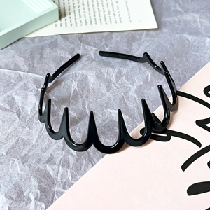 Detail of black wavy non-slip headband with shark teeth on a stylish paper background