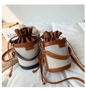 Detail of vintage canvas bucket bag with leather trim and adjustable shoulder strap