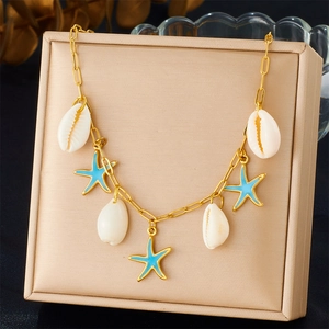 Detail of gold necklace featuring white shell and blue starfish charms in jewelry box