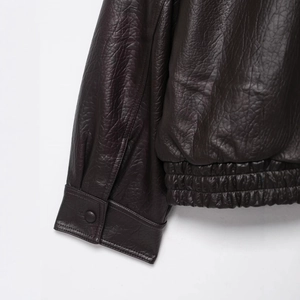 Veste en cuir marron foncé avec ourlet élastique et poignets boutonnés texture grainée