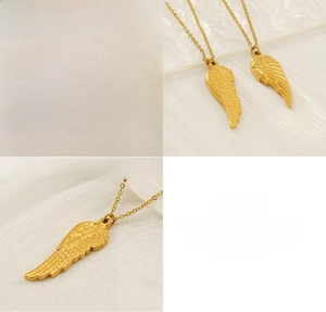 Detail of polished gold stainless steel angel wing pendant with textured feathers