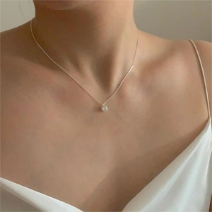 Close-up of minimalist 925 sterling silver necklace with pearl pendant on model