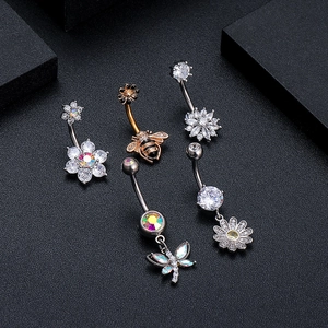 Close-up of zircon navel rings with bee, flower, and dragonfly designs in silver and rose gold