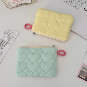 Detailed top view of quilted heart-pattern mini organizers in yellow and mint green