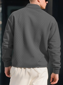 Close-up of the back view showing geometric textured jacquard fabric on a dark gray polo