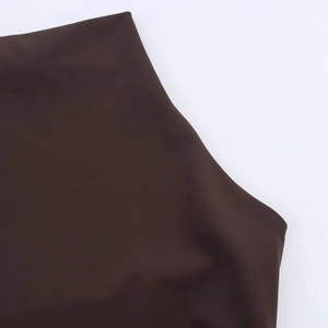 Close-up of deep brown stretch fabric texture and ruched detailing on a bodycon dress