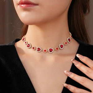 Dettaglio della collana vintage dorata con cuori rossi e diamanti indossata dalla modella