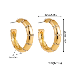 Gros plan de boucles d'oreilles C dorées avec diamants et dimensions précises