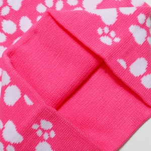 Detailed macro shot of bright pink knit fabric with white paw print pattern and texture