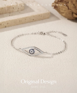 Detail of S925 sterling silver evil eye bracelet with blue zircons on stone background