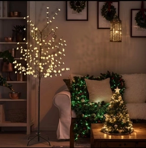 Warm white LED cherry blossom tree lamp standing by a sofa in a cozy home living room