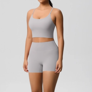 Detail of light gray racerback sports bra and high-waisted shorts yoga set on model