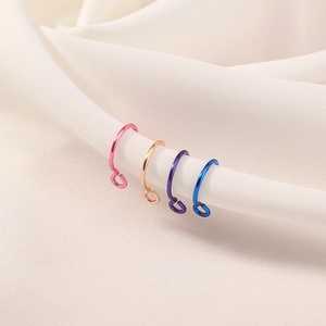 Macro shot of U-shaped non-piercing nose rings in pink, rose gold, blue, and purple colors