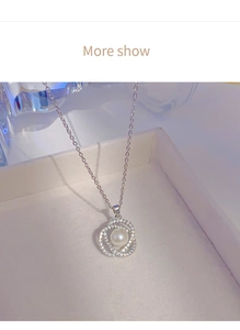 Detail of silver dual-loop pendant with cubic zirconia and a white pearl in a gift box