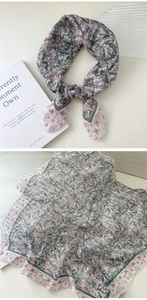 Detail view of cotton linen scarf featuring green leaves, pink flowers and butterfly prints