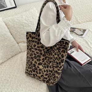 Detail of leopard print faux fur tote bag showing plush texture and metal logo plate