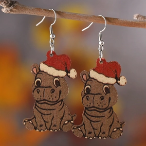 Detail shot of Christmas highland cow wooden earrings hanging on a natural branch