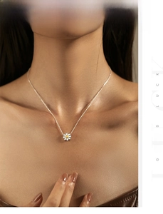 Close-up of s925 silver daisy necklace with white enamel petals on a female model