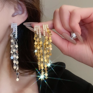 Detail view of long tassel earrings with silver needles and shimmering zircon sequins