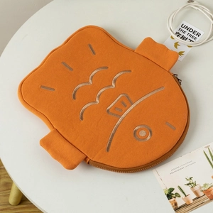 Close-up of orange fish-shaped laptop sleeve with detailed embroidery and fin design
